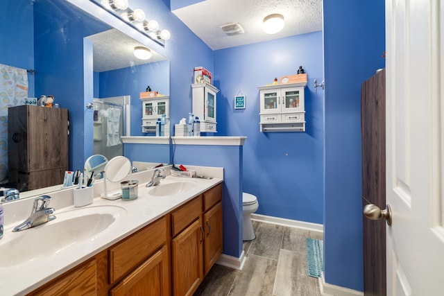 214 Cobblestone Lndg, Mount Juliet, TN 37122 - full bathroom with wood finished floors, a textured ceiling, baseboards, toilet, and double vanity
