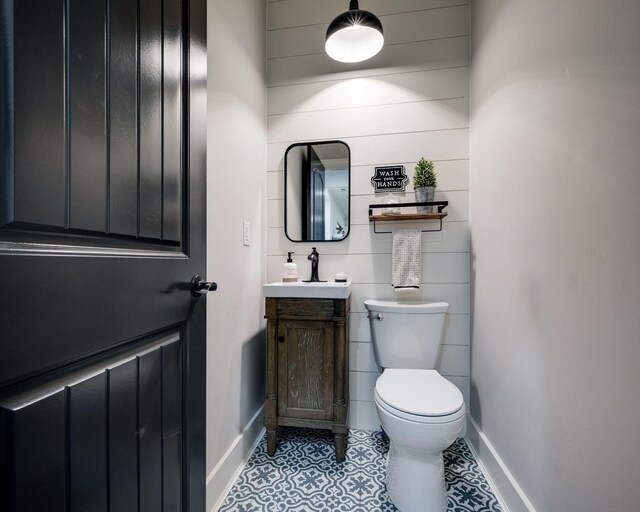 1092 Meeks Cemetery Rd, Burns, TN 37029 - half bath featuring baseboards, toilet, vanity, tile patterned flooring, and wooden walls