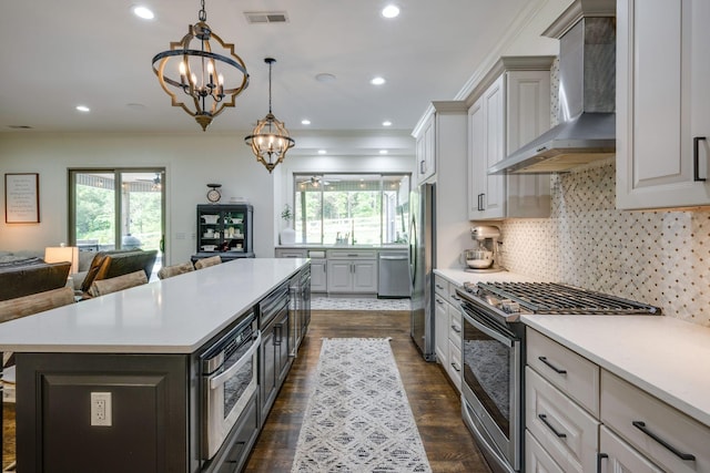 1092 Meeks Cemetery Rd, Burns, TN 37029 - kitchen featuring wall chimney exhaust hood, stainless steel appliances, a chandelier, a kitchen island, and light countertops