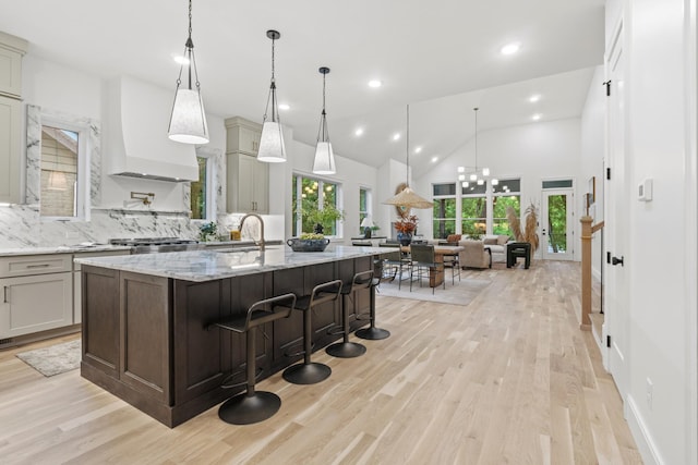 1438 Janie Ave, Nashville, TN 37216 - kitchen featuring custom range hood, tasteful backsplash, a kitchen island with sink, light wood finished floors, and recessed lighting