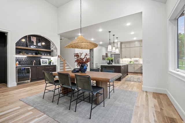 1438 Janie Ave, Nashville, TN 37216 - dining space with wine cooler, bar with sink, light wood-style floors, stairs, and baseboards