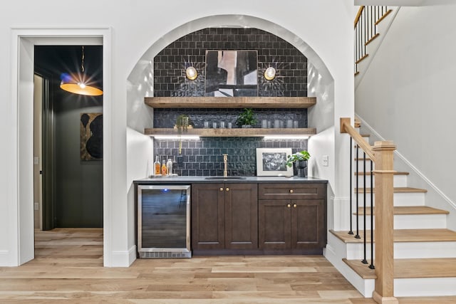 1438 Janie Ave, Nashville, TN 37216 - indoor wet bar with wine cooler, stairs, light wood-style flooring, and tasteful backsplash