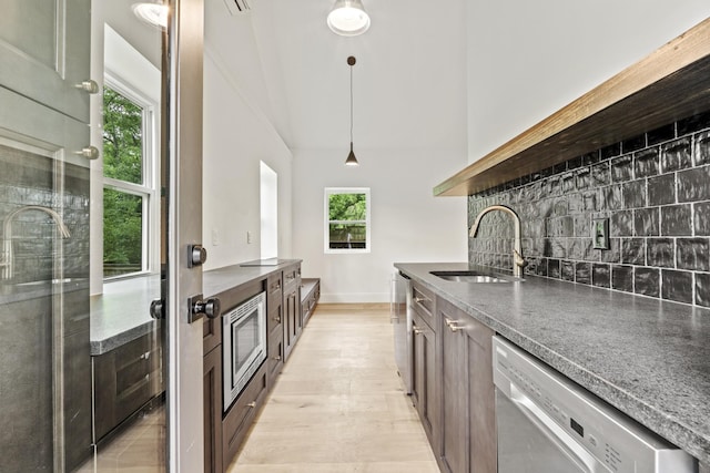 1438 Janie Ave, Nashville, TN 37216 - kitchen featuring stainless steel appliances, a sink, decorative backsplash, light wood-style floors, and pendant lighting