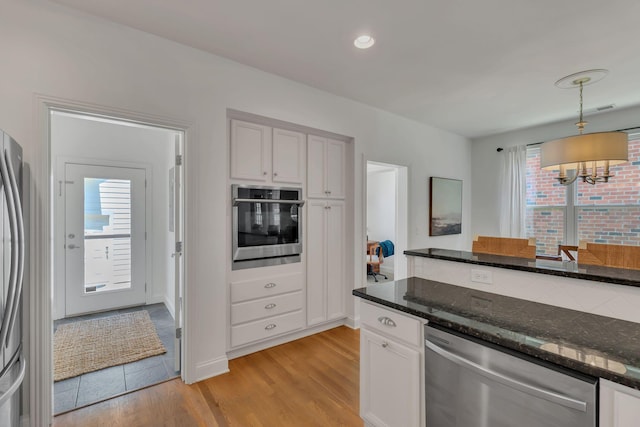 118 Jasper Ave, Franklin, TN 37064 - kitchen featuring stainless steel appliances, a chandelier, dark stone counters, light wood-style flooring, and pendant lighting