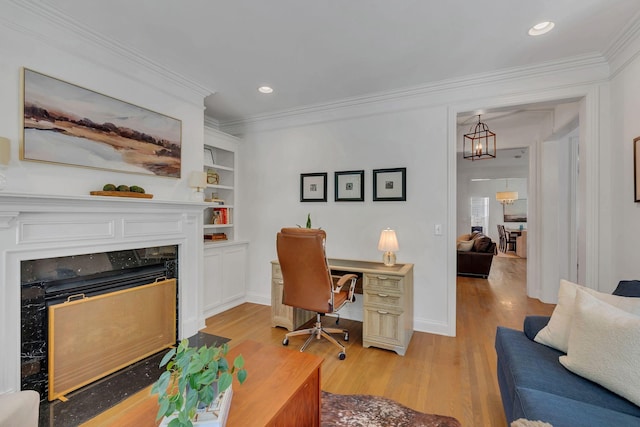 118 Jasper Ave, Franklin, TN 37064 - home office featuring light wood finished floors, a fireplace, a chandelier, ornamental molding, and built in shelves