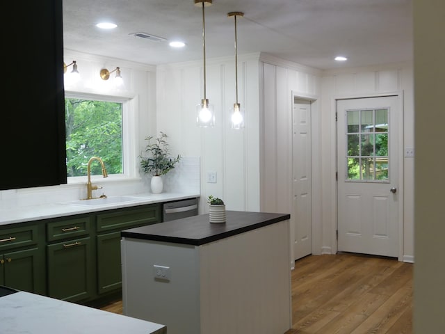 205 W 5th St, Parsons, TN 38363 - kitchen with a sink, green cabinets, wood finished floors, dishwasher, and pendant lighting