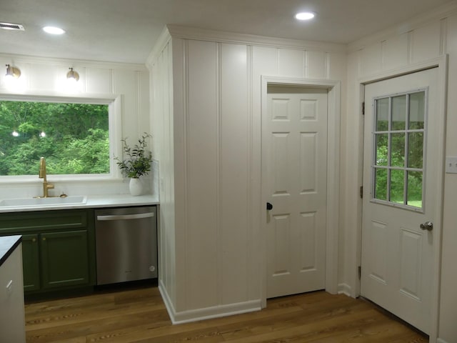 205 W 5th St, Parsons, TN 38363 - kitchen with stainless steel dishwasher, a sink, wood finished floors, a decorative wall, and healthy amount of natural light