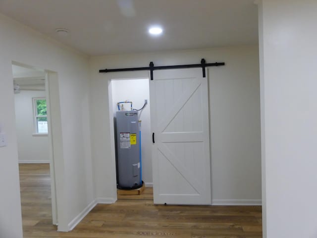 205 W 5th St, Parsons, TN 38363 - interior space featuring electric water heater, a barn door, wood finished floors, baseboards, and recessed lighting