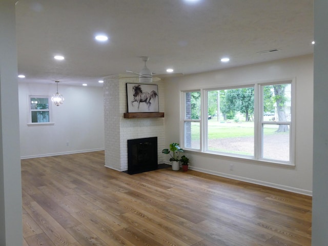 205 W 5th St, Parsons, TN 38363 - unfurnished living room with baseboards, a brick fireplace, wood finished floors, and recessed lighting