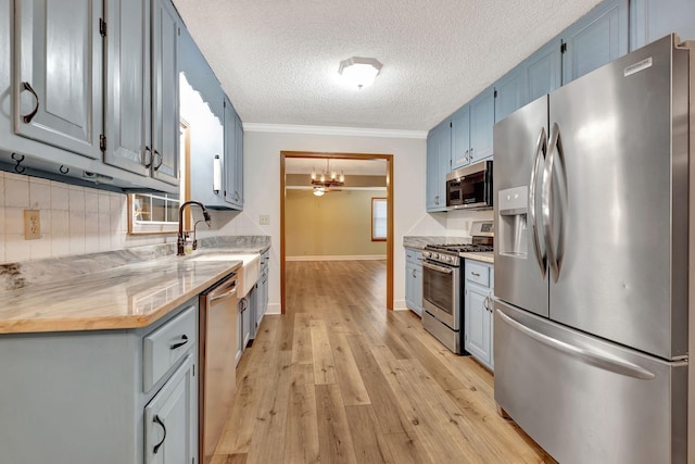 33 Edgewood Rd, Alexandria, TN 37012 - kitchen with appliances with stainless steel finishes, a textured ceiling, blue cabinetry, light wood-style floors, and light countertops