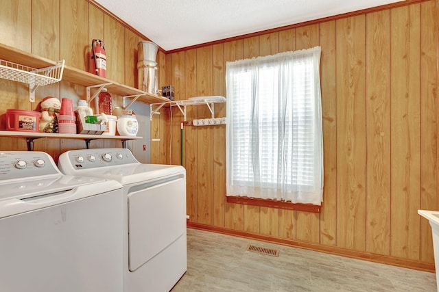33 Edgewood Rd, Alexandria, TN 37012 - laundry area featuring washer and clothes dryer, wooden walls, light wood-type flooring, baseboards, and a textured ceiling