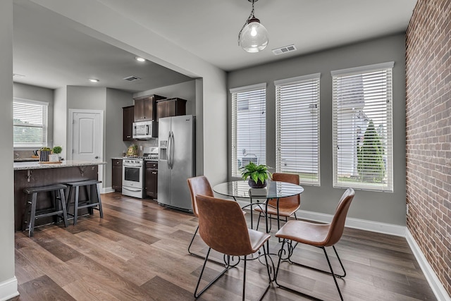1010 Keeneland Dr, Spring Hill, TN 37174 - dining area with dark wood finished floors, brick wall, and baseboards