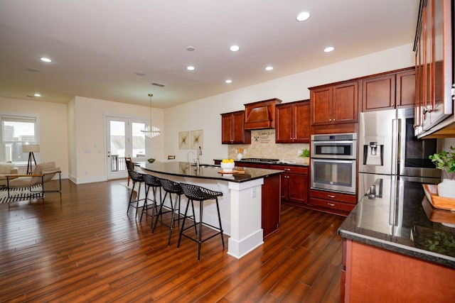 1820 Lanceford Ct, Franklin, TN 37067 - kitchen featuring appliances with stainless steel finishes, custom range hood, dark wood-style flooring, a breakfast bar area, and backsplash