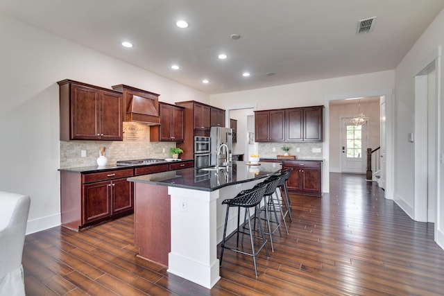 1820 Lanceford Ct, Franklin, TN 37067 - kitchen with appliances with stainless steel finishes, dark wood-type flooring, a kitchen bar, an island with sink, and backsplash