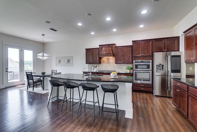 1820 Lanceford Ct, Franklin, TN 37067 - kitchen featuring appliances with stainless steel finishes, custom range hood, a chandelier, a breakfast bar area, and backsplash
