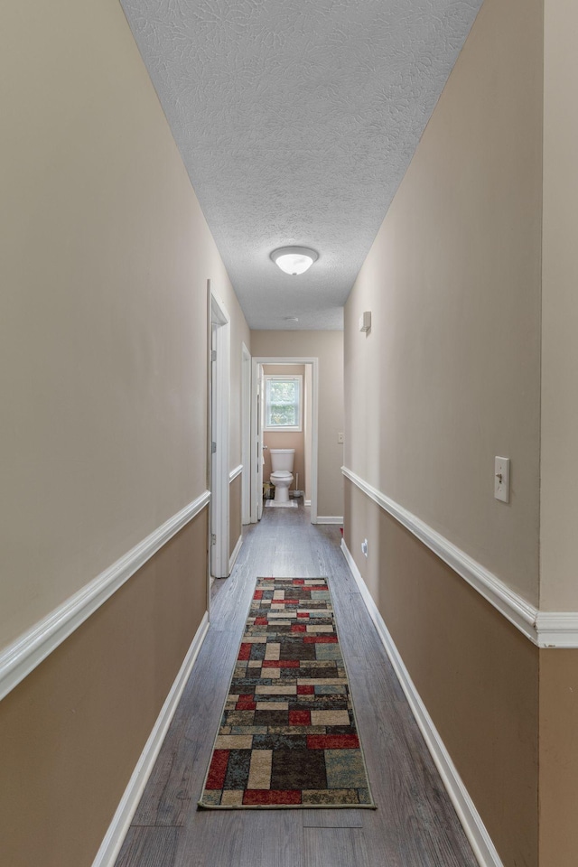 862 College St, Portland, TN 37148 - corridor featuring wood finished floors, a textured ceiling, and baseboards