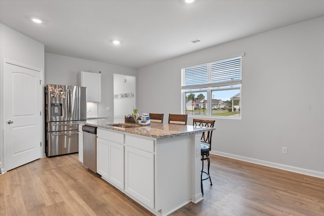 2405 Quinn Dr, White House, TN 37188 - kitchen with stainless steel appliances, a sink, a kitchen island with sink, white cabinets, and recessed lighting