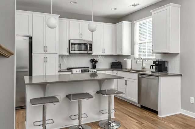 2120 Herman St Unit 8, Nashville, TN 37208 - kitchen with appliances with stainless steel finishes, a sink, a kitchen bar, white cabinetry, and recessed lighting