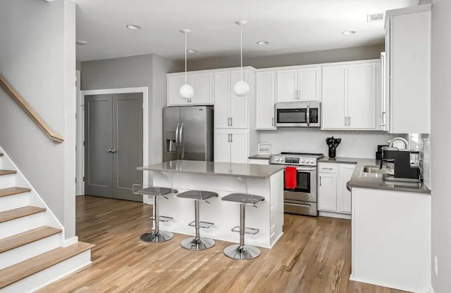 2120 Herman St Unit 8, Nashville, TN 37208 - kitchen with stainless steel appliances, light wood-type flooring, a breakfast bar, white cabinetry, and recessed lighting