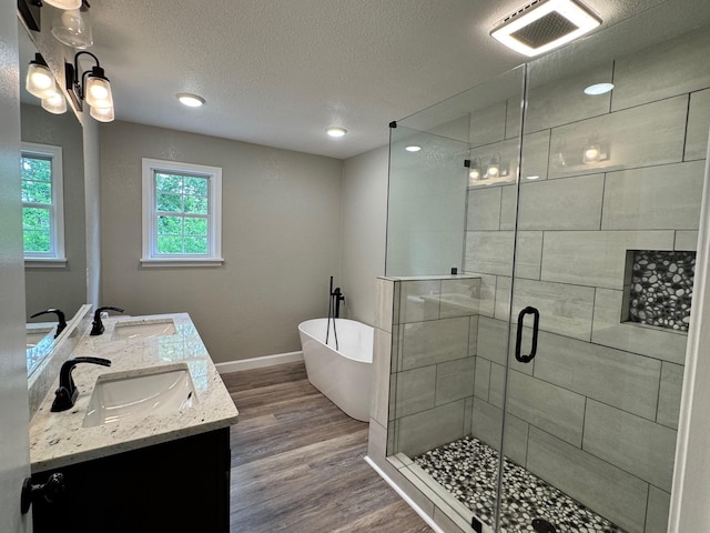 410 Sunset Ln, Monterey, TN 38574 - full bathroom with a freestanding bath, wood finished floors, a stall shower, double vanity, and a textured ceiling