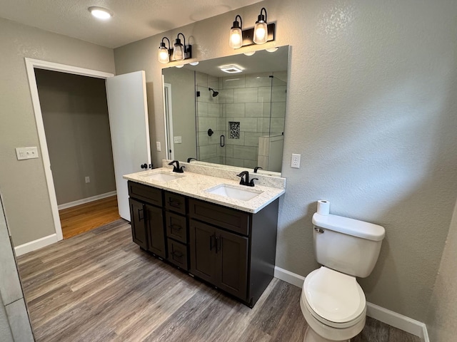 410 Sunset Ln, Monterey, TN 38574 - full bath featuring a stall shower, wood finished floors, baseboards, double vanity, and toilet