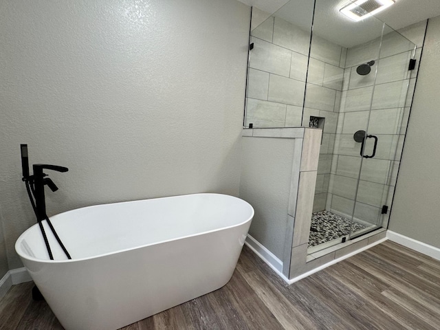 410 Sunset Ln, Monterey, TN 38574 - bathroom featuring wood finished floors, a stall shower, baseboards, and a freestanding bath