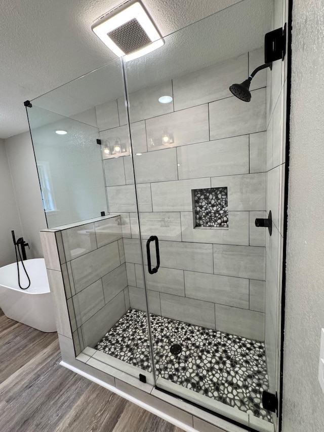 410 Sunset Ln, Monterey, TN 38574 - full bath with wood finished floors, a freestanding tub, a stall shower, and a textured ceiling