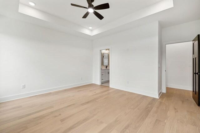 811 Oconner St, Smithville, TN 37166 - unfurnished bedroom with a raised ceiling, baseboards, light wood-style flooring, recessed lighting, and ensuite bathroom