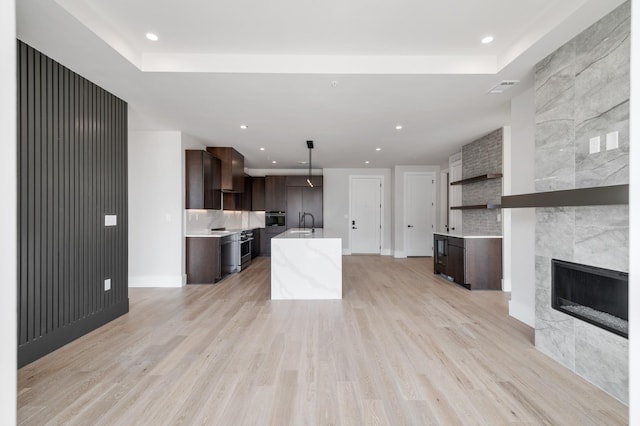 321 31st Ave N Unit B8 A, Nashville, TN 37203 - kitchen featuring dark brown cabinets, light countertops, oven, backsplash, and light wood-style flooring