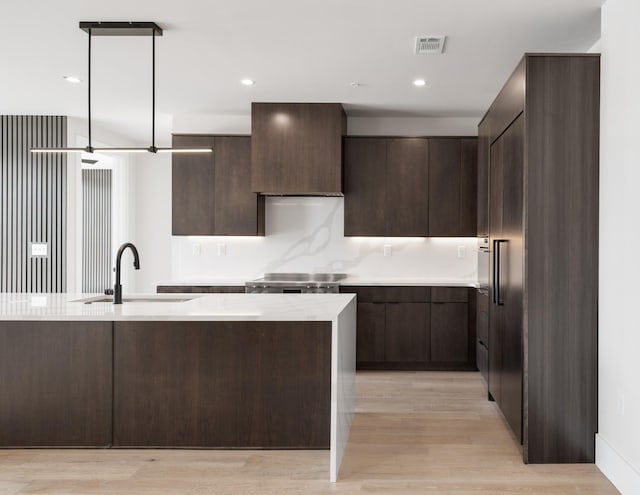 321 31st Ave N Unit B8 A, Nashville, TN 37203 - kitchen with light countertops, dark brown cabinetry, modern cabinets, light wood-type flooring, and stainless steel range oven
