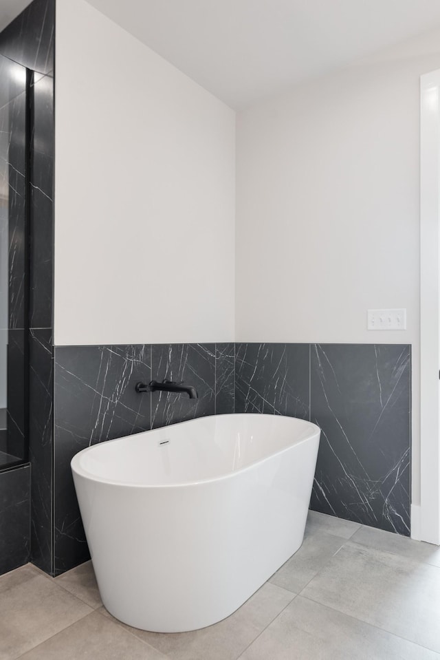 321 31st Ave N Unit B8 A, Nashville, TN 37203 - bathroom featuring tile walls, a freestanding tub, and a wainscoted wall