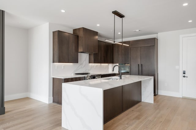 321 31st Ave N Unit B8 A, Nashville, TN 37203 - kitchen with modern cabinets, dark brown cabinetry, light wood finished floors, a center island with sink, and recessed lighting