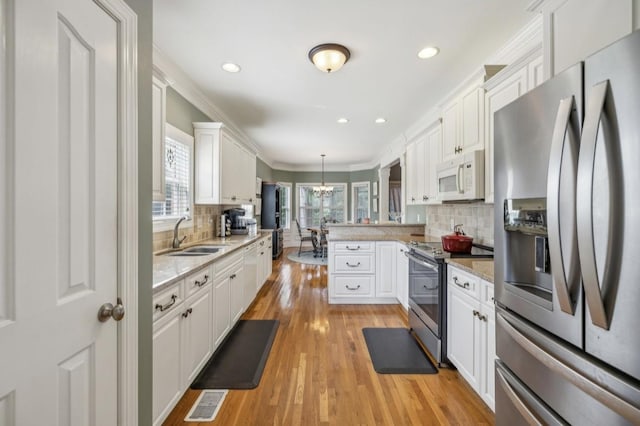 5122 Stonewood Dr, Smyrna, TN 37167 - kitchen with stainless steel appliances, a sink, white cabinetry, crown molding, and recessed lighting