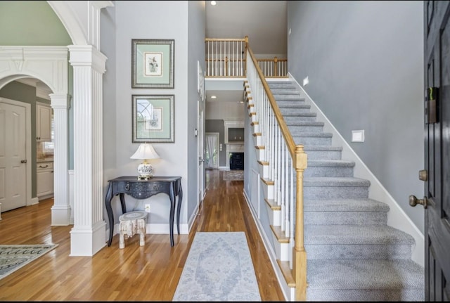5122 Stonewood Dr, Smyrna, TN 37167 - entrance foyer with ornate columns, arched walkways, a towering ceiling, wood finished floors, and stairs