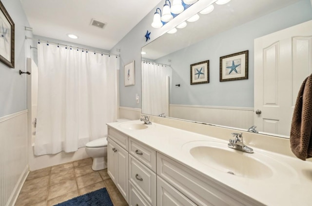 5122 Stonewood Dr, Smyrna, TN 37167 - bathroom featuring toilet, double vanity, a wainscoted wall, shower / tub combo, and tile patterned flooring