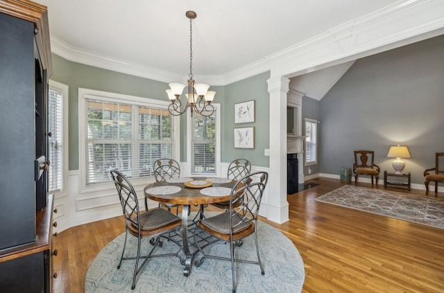5122 Stonewood Dr, Smyrna, TN 37167 - dining space featuring wood finished floors, a chandelier, a fireplace, wainscoting, and crown molding