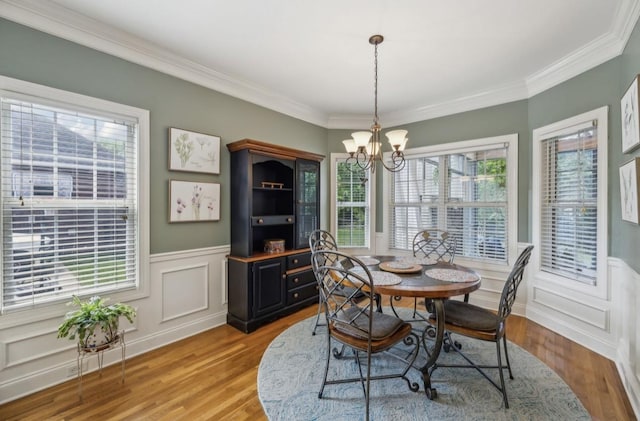 5122 Stonewood Dr, Smyrna, TN 37167 - dining area with a chandelier, light wood finished floors, crown molding, a wainscoted wall, and a decorative wall
