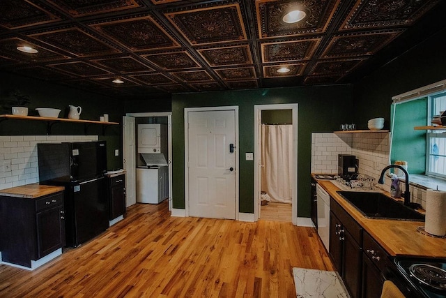 800 Riverside Dr, Columbia, TN 38401 - kitchen with open shelves, butcher block countertops, a sink, black appliances, and stacked washer / drying machine