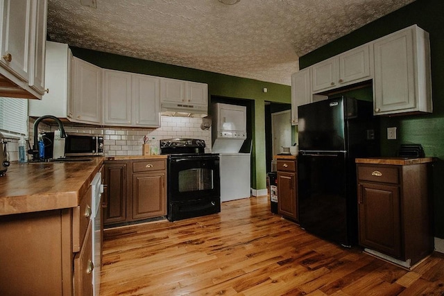 800 Riverside Dr, Columbia, TN 38401 - kitchen featuring black appliances, stacked washer / drying machine, light wood-style floors, decorative backsplash, and a textured ceiling