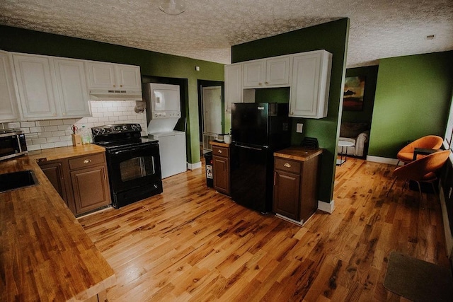 800 Riverside Dr, Columbia, TN 38401 - kitchen with estacked washer and dryer, black appliances, under cabinet range hood, a textured ceiling, and wooden counters