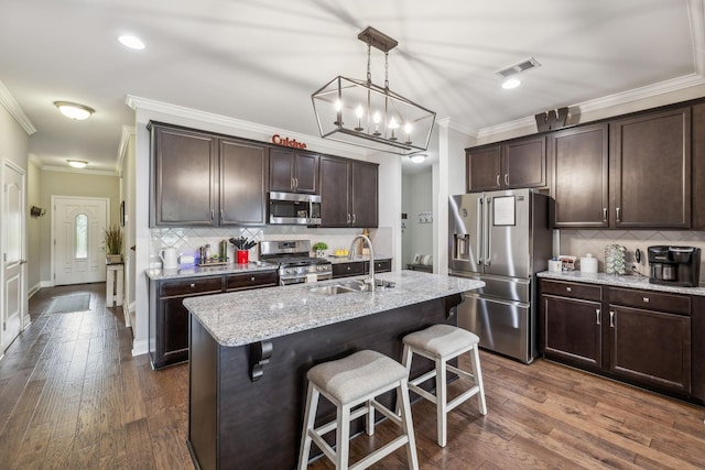1420 Whispering Oaks Dr, Lebanon, TN 37090 - kitchen with appliances with stainless steel finishes, a sink, crown molding, dark brown cabinets, and a breakfast bar