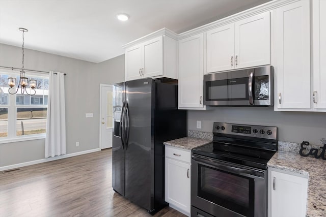 813 S Mountain St, Smithville, TN 37166 - kitchen featuring appliances with stainless steel finishes, a chandelier, light wood-style flooring, and white cabinets