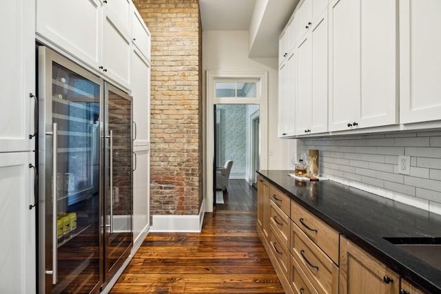 1051 W Main St, Franklin, TN 37064 - kitchen with beverage cooler, dark wood-style flooring, tasteful backsplash, dark stone countertops, and baseboards