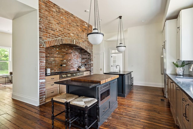 1051 W Main St, Franklin, TN 37064 - kitchen featuring a kitchen island with sink, baseboards, stainless steel appliances, and a sink