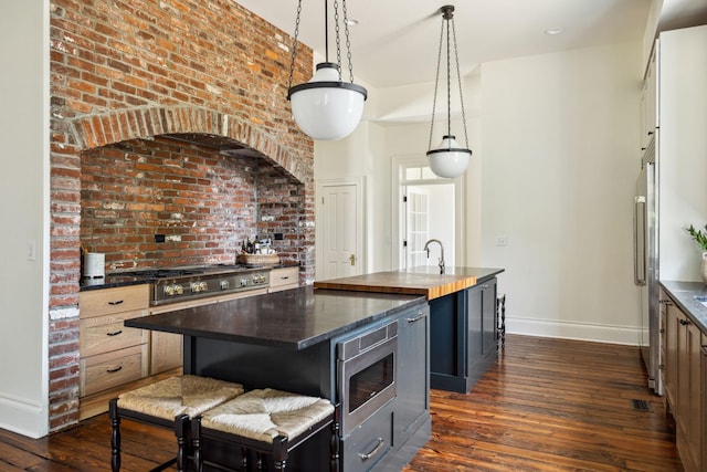 1051 W Main St, Franklin, TN 37064 - kitchen with baseboards, an island with sink, appliances with stainless steel finishes, dark wood finished floors, and hanging light fixtures