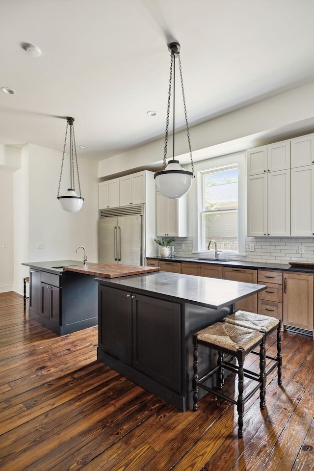 1051 W Main St, Franklin, TN 37064 - kitchen with stainless steel built in refrigerator, a center island, a sink, dark countertops, and decorative backsplash