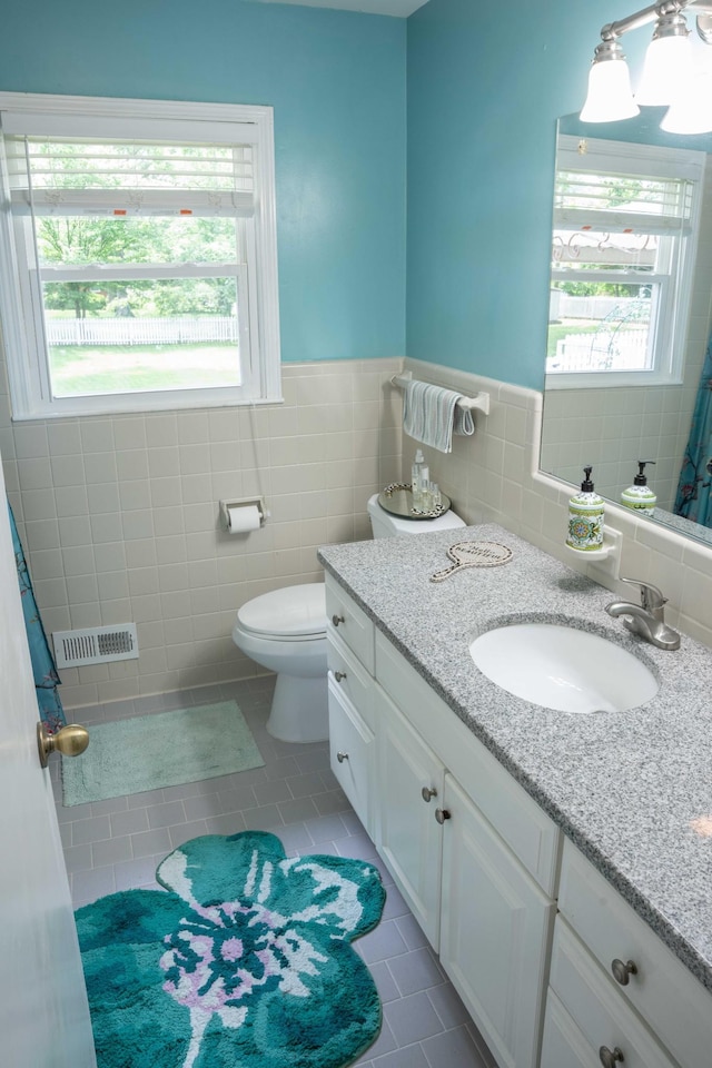 4011 Sheddan Dr, Columbia, TN 38401 - bathroom with toilet, tile walls, tile patterned floors, vanity, and a wainscoted wall