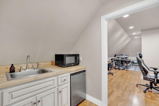 6948 Whispering Oaks Dr, Springfield, TN 37172 - kitchen with a sink, black microwave, vaulted ceiling, light wood-style flooring, and white cabinets