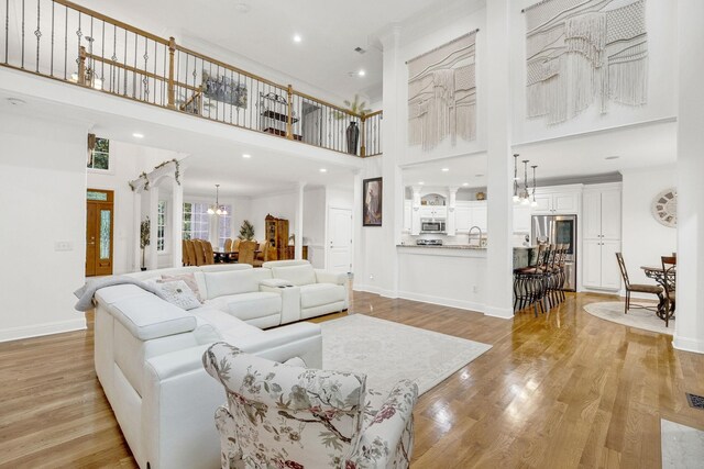 6948 Whispering Oaks Dr, Springfield, TN 37172 - living room with a towering ceiling, light wood-type flooring, a chandelier, baseboards, and recessed lighting