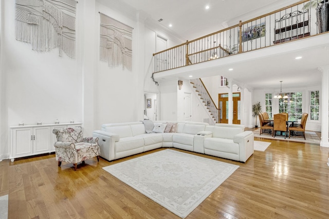 6948 Whispering Oaks Dr, Springfield, TN 37172 - living room with a chandelier, a high ceiling, stairs, light wood-type flooring, and crown molding